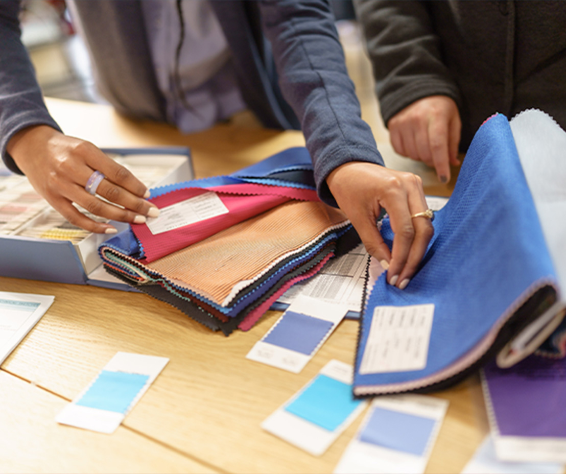 Hands looking through fabric samples